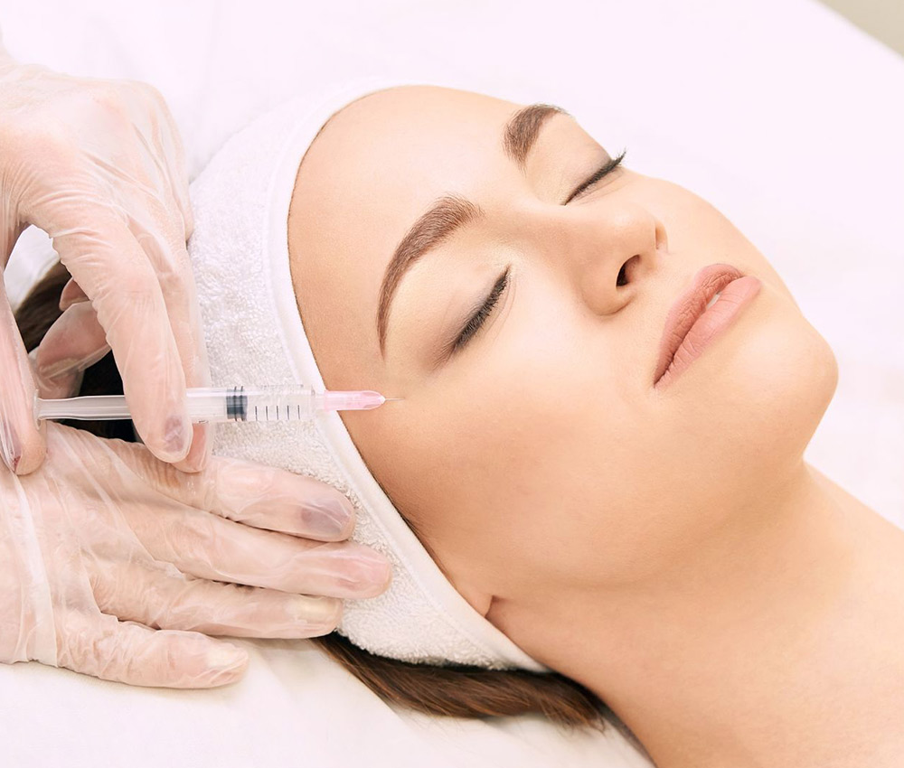 Mujer recibiendo un tratamiento de mesoterapia facial sobre su rostro